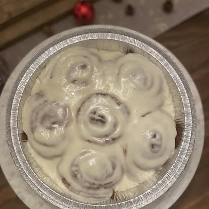 Cinnamon rolls with cream cheese icing in a foil pan